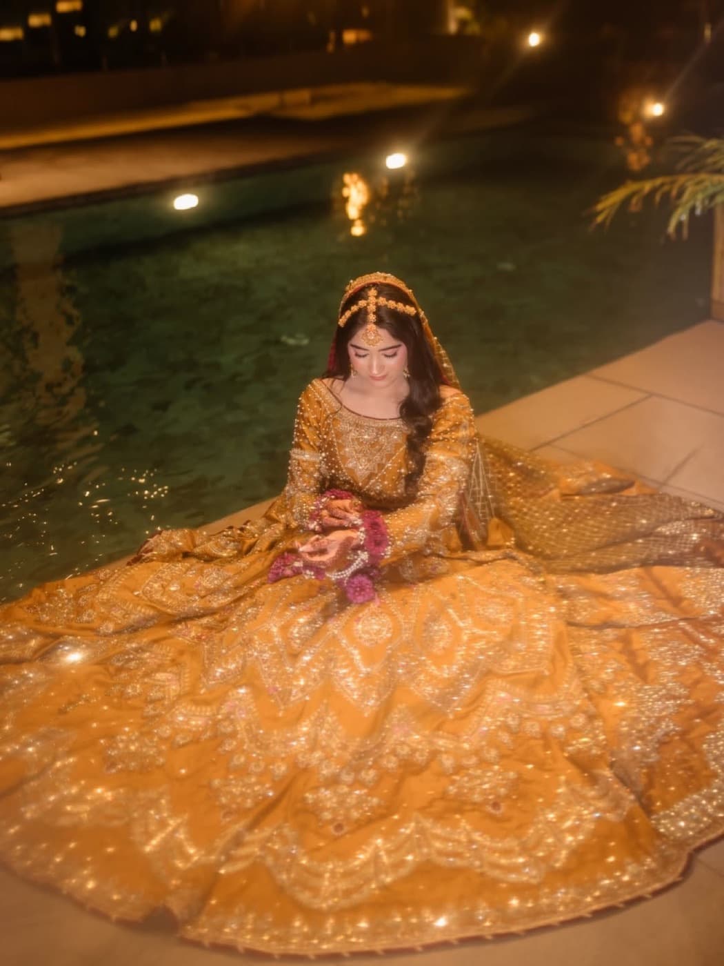 Bride in gold bridal wear by the water